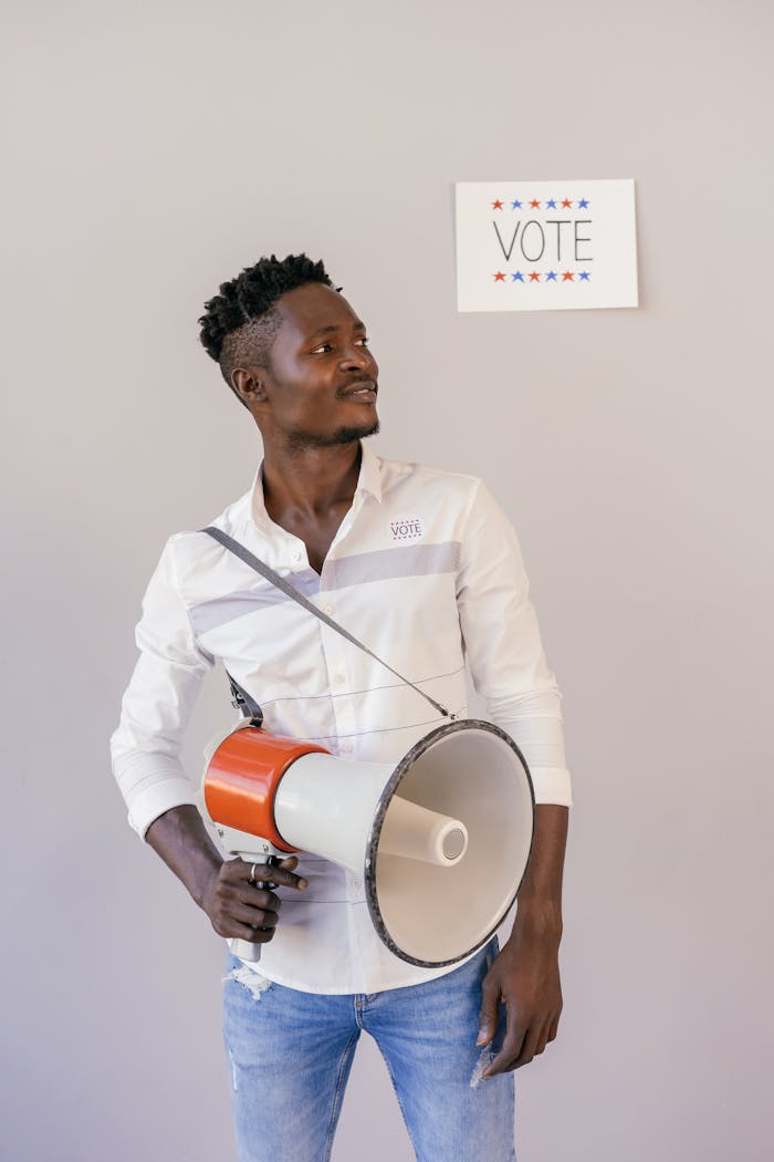 Confident African American man holding a megaphone, encouraging people to vote.