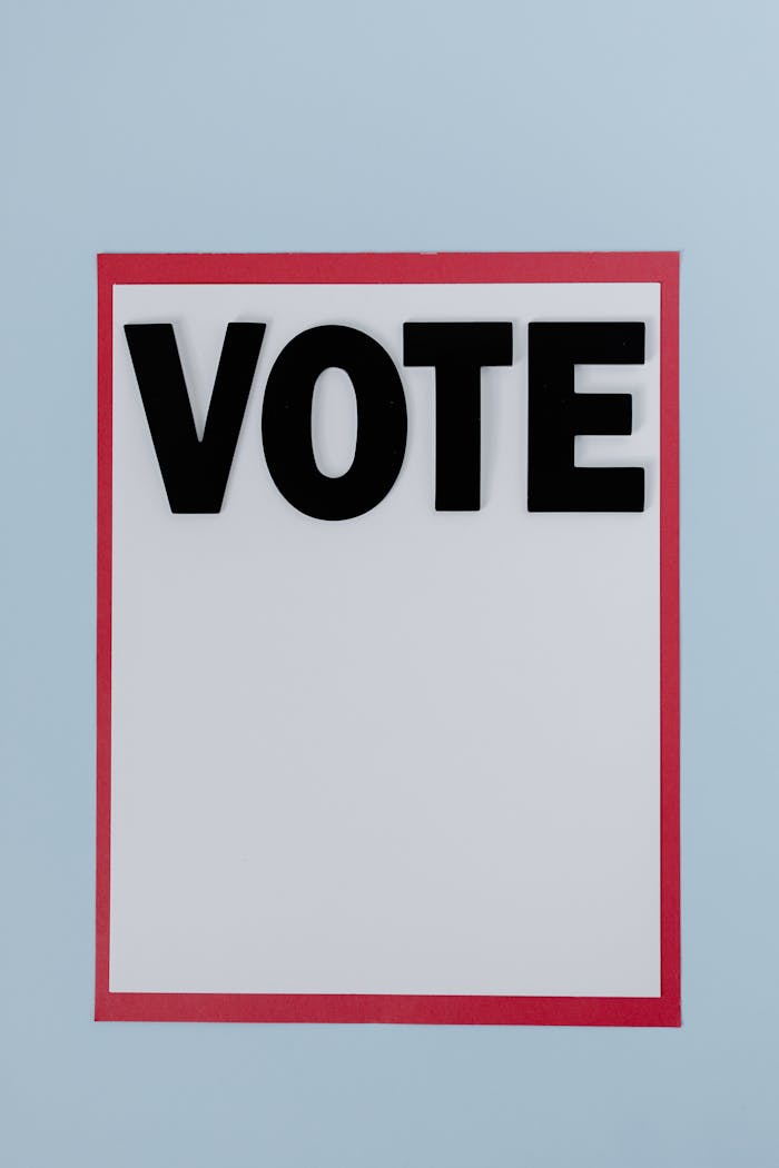 A bold 'Vote' sign with a red border on a pale blue background.