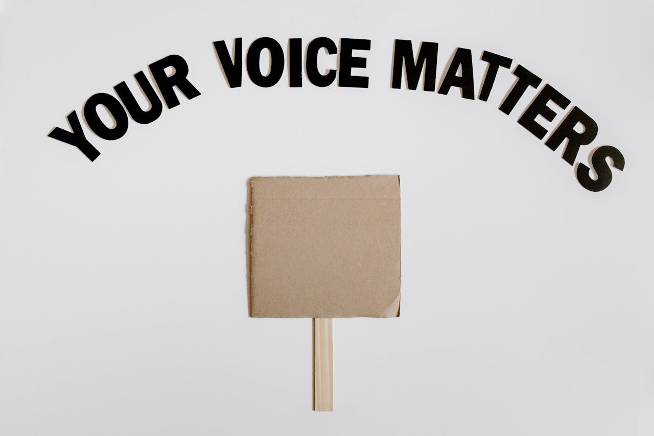Image of a blank protest sign with 'Your Voice Matters' text overhead on a white background.