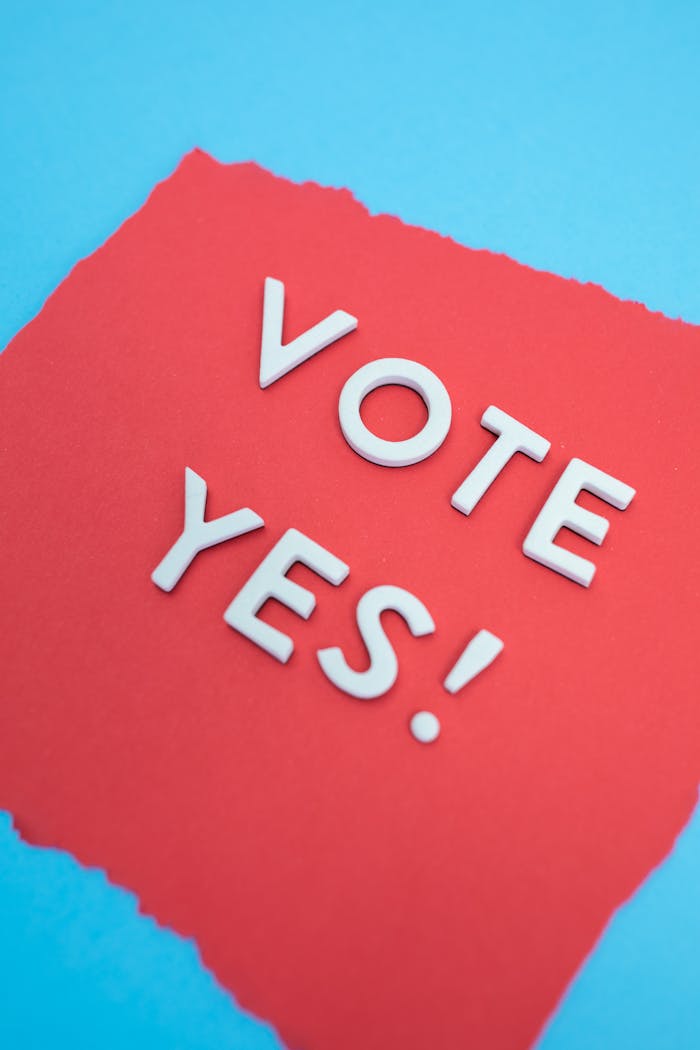 Inspirational 'Vote Yes' message on vibrant red and blue paper background, promoting positive engagement.